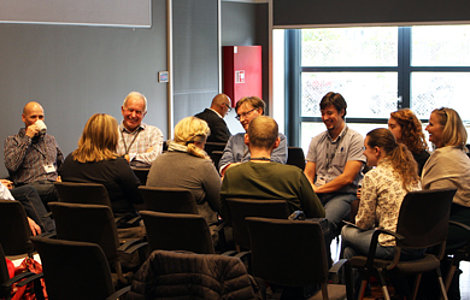 Teilnehmer der Tagung sitzen in einem Workshop zu Themen über User Experience und Artificial Intelligence